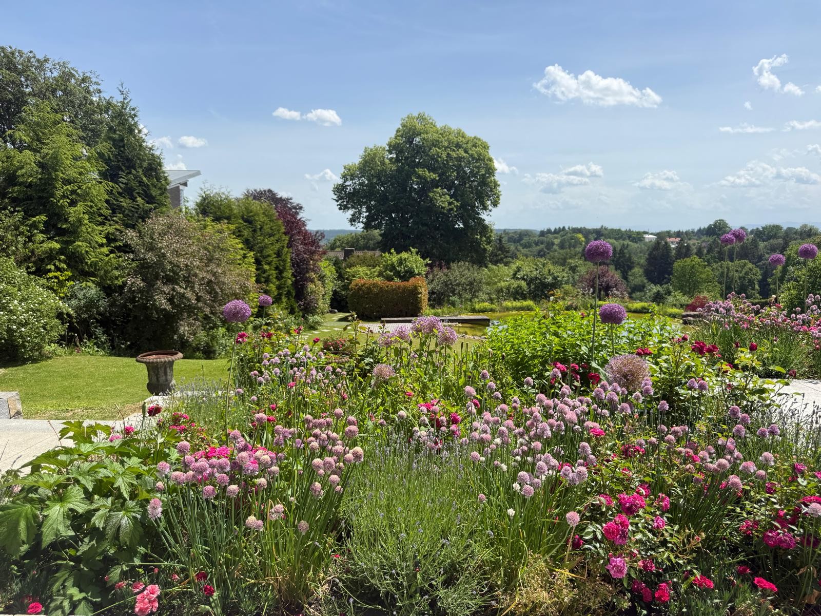 Terrassenblick über die blütenreichen Pflanzungsränder und den Garten in Starnberg
