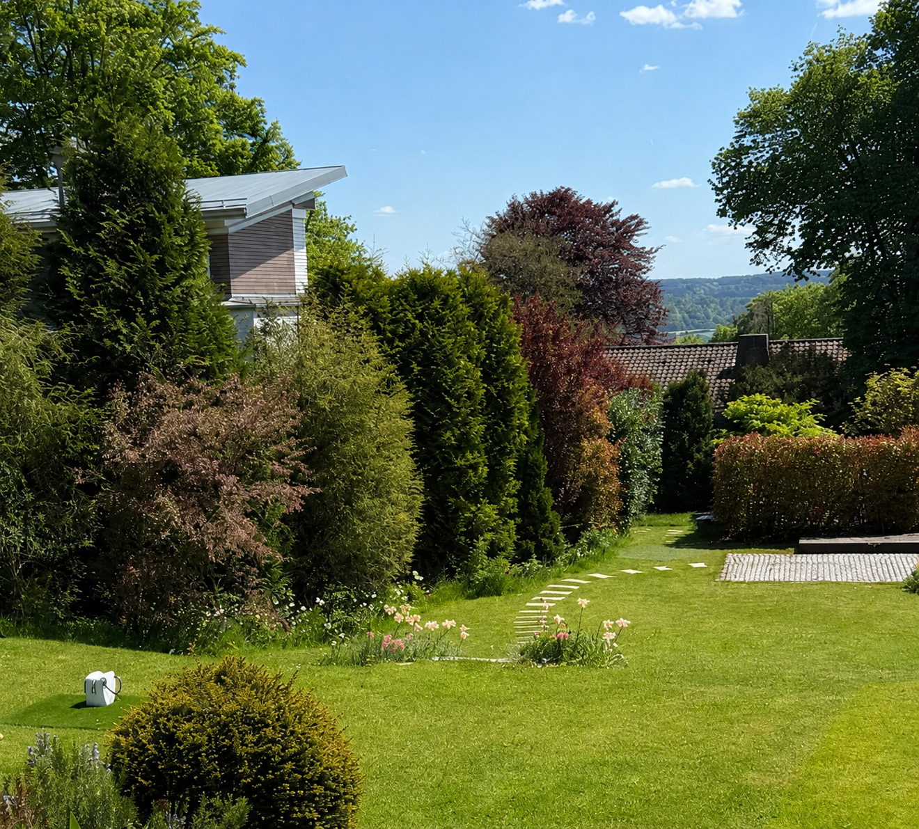 Geschwungener Weg zwischen den vielschichtig bepflanzten Gartenrändern