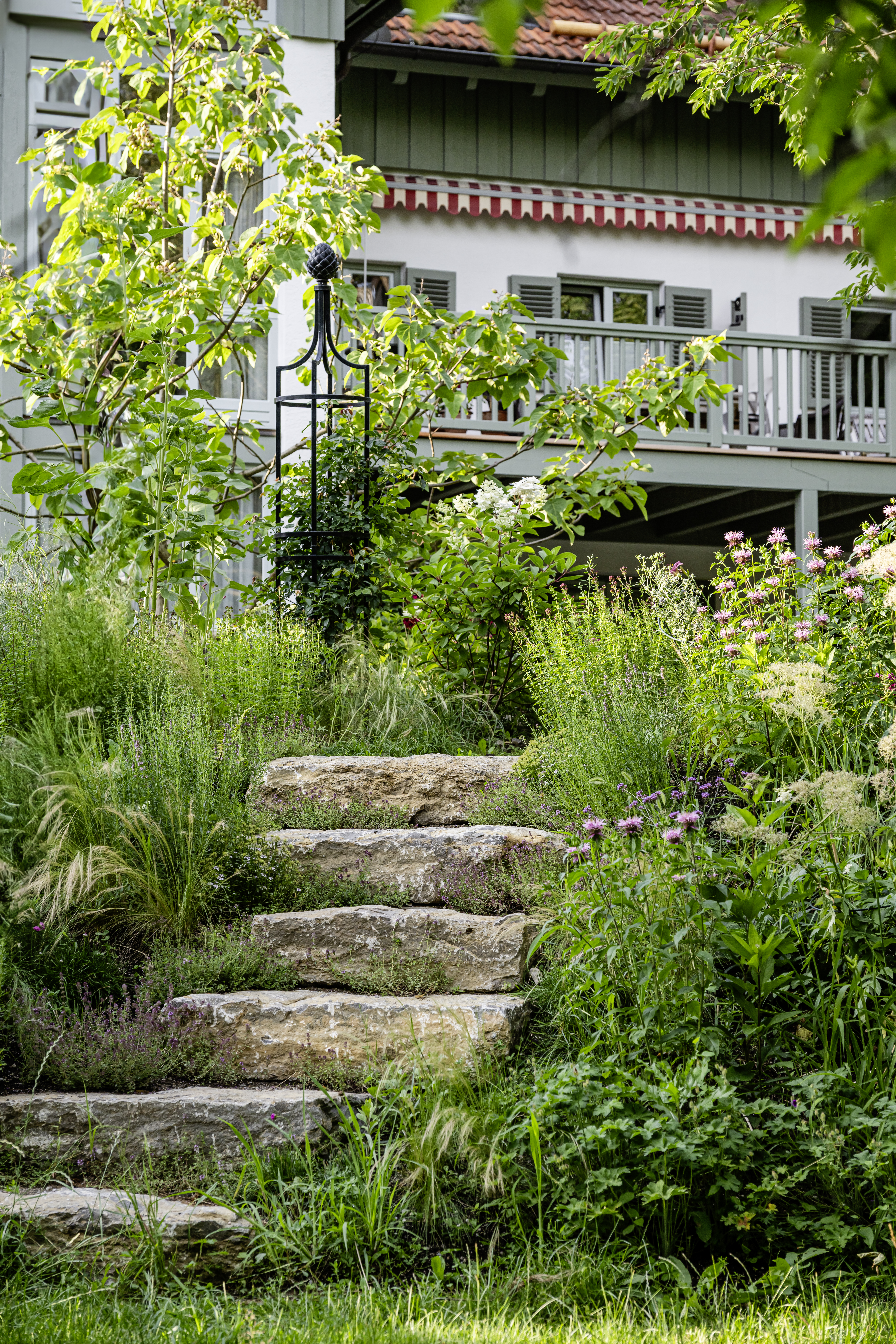 Natursteintreppe zwischen üppiger Pflanzung im Garten Windach